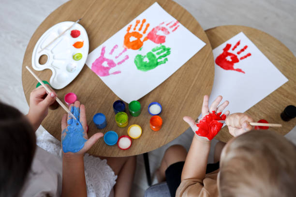 istock Children's drawing workshop, happy children make handprints with paint 1477486215