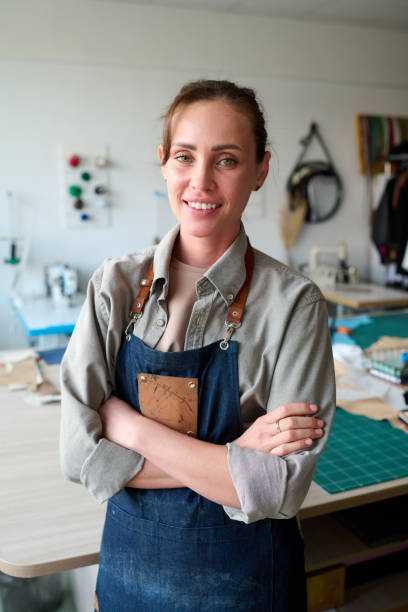 istock Young successful female leather worker in apron looking at camera 1477487710