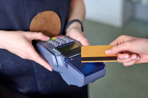 istock Hands of shop assistant holding card reader during contactless payment 1477487804