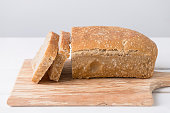 Sliced loaf of white sourdough bread on light background