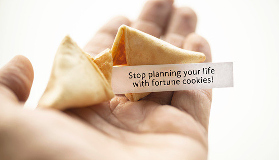 A hand holding broken fortune cookie.