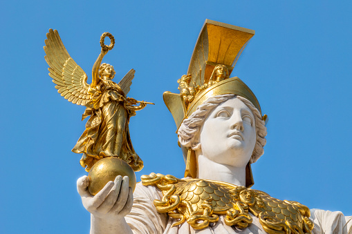 Head-shot of gilded marble statue of Pallas Athena holding goddess of victory Nike in tight head-shot close-up, unveiled in 1902 in front of the Austrian Parliament building by Austrian sculptor Carl Kundmann (1838-1919)