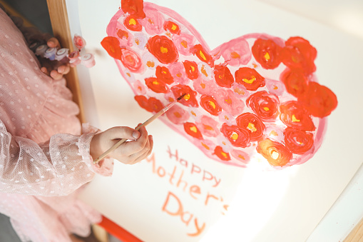 A child draws a heart for mom for mother's day.
