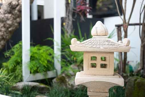 A classic design of Japanese lighting lamp that made from stone material, using for decorate the garden. Close-up and selective focus.