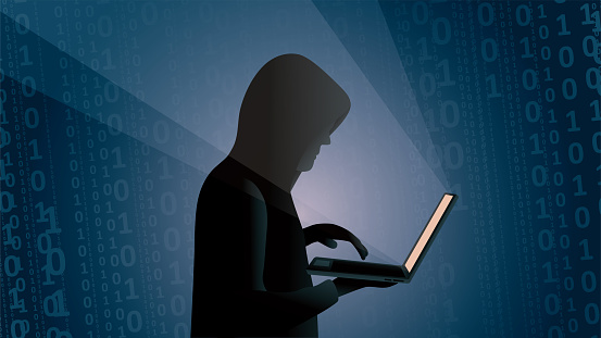 Side view of a young hacker writing binary codes in the dark on a blue background.