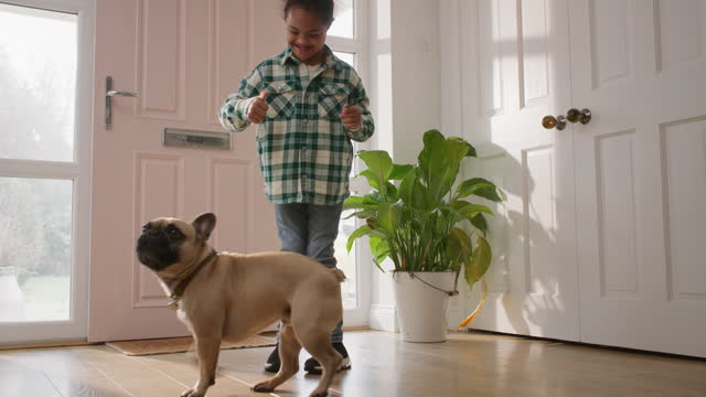 Multiracial boy with Down syndrome doing tricks with dog