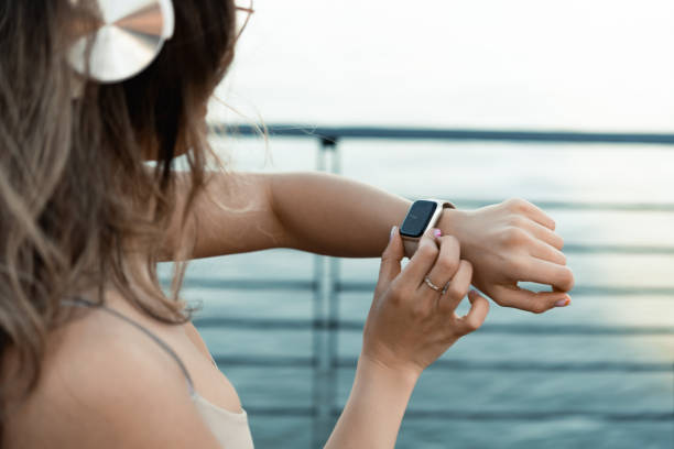 istock Young woman checking her sporting smart watch app while jogging 1477506519