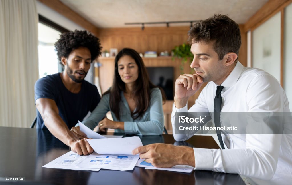 Financial advisor talking to a couple about their business plan Financial advisor talking to a couple about their business plan - home finances concepts Tax Stock Photo