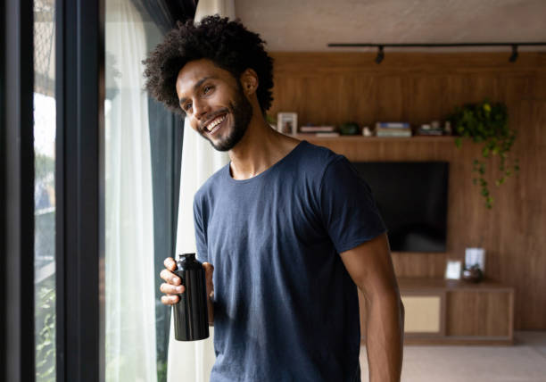 istock Happy man hydrating after finishing his home workout 1477508285