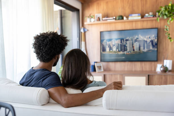 istock Loving couple watching television at home 1477508378