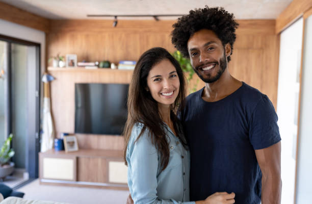 istock Loving couple smiling at home and looking at the camera 1477508397