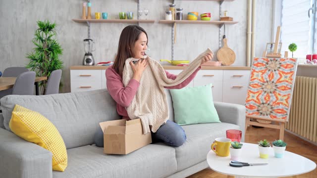 Young Woman Unboxing A Package With A New Sweater