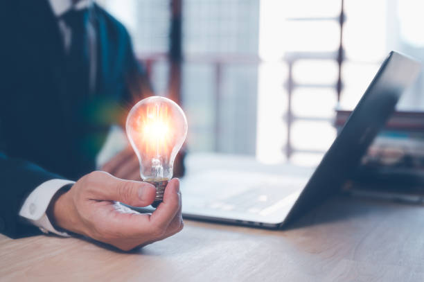 istock ideas inspiration concept, businessman with illuminated light bulb, working on laptop at office, concept for idea, innovation and inspiration in business, business opportunities 1477512630
