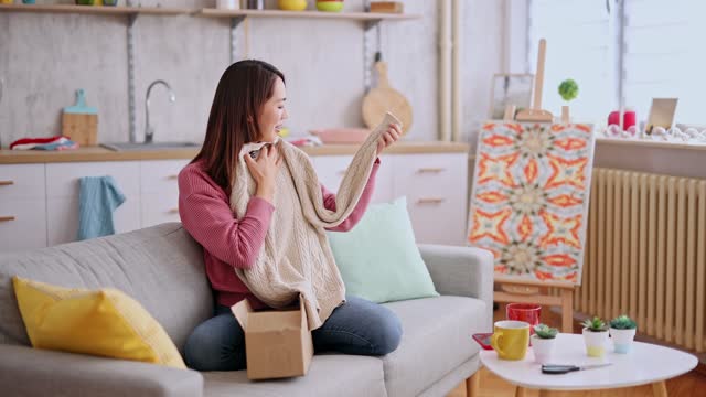Young Woman Unboxing A Package With A New Sweater