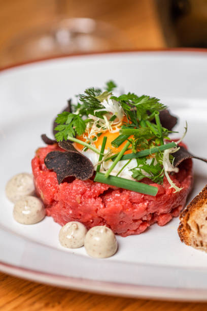 Gourmet food Beef Tartare with egg, herbs, chives and truffle cream in elegant restaurant