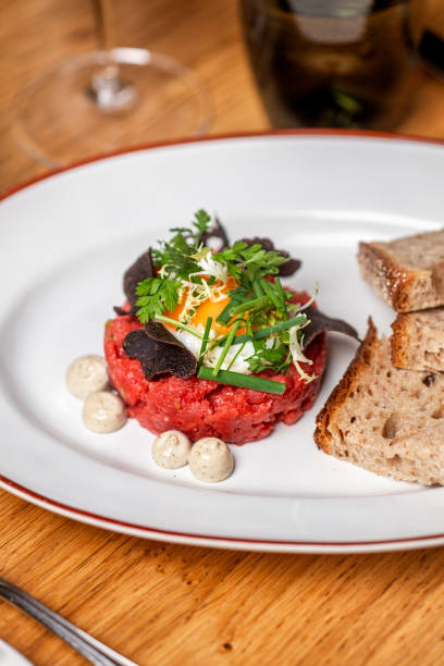 Gourmet food Beef Tartare with egg, herbs, chives and truffle cream in elegant restaurant