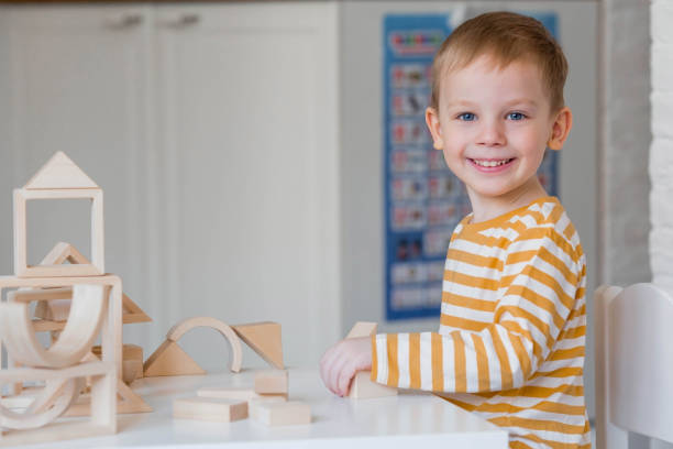 istock A little boy of 3 years old is playing a developing logistics constructor. Children's wooden toys. Montessori for child development. 1477515892