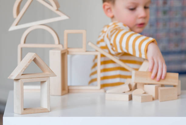 istock A little boy of 3 years old is playing a developing logistics constructor. Children's wooden toys. Montessori for child development. 1477515902