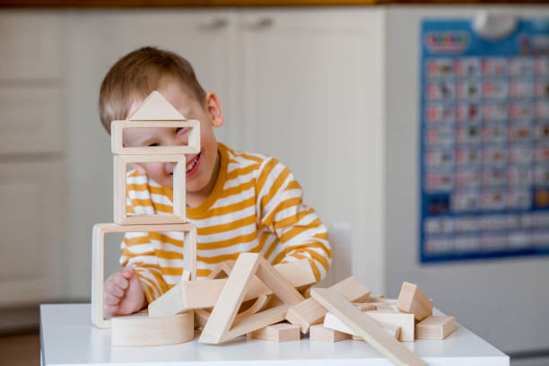 istock A little boy of 3 years old is playing a developing logistics constructor. Children's wooden toys. Montessori for child development. 1477515906