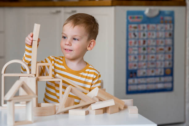 istock A little boy of 3 years old is playing a developing logistics constructor. Children's wooden toys. Montessori for child development. 1477515913