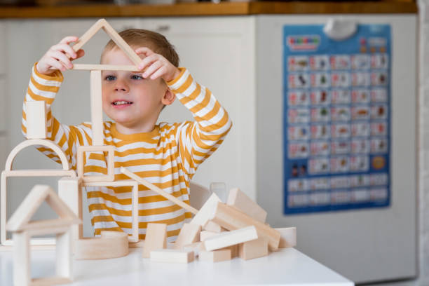 istock A little boy of 3 years old is playing a developing logistics constructor. Children's wooden toys. Montessori for child development. 1477515915