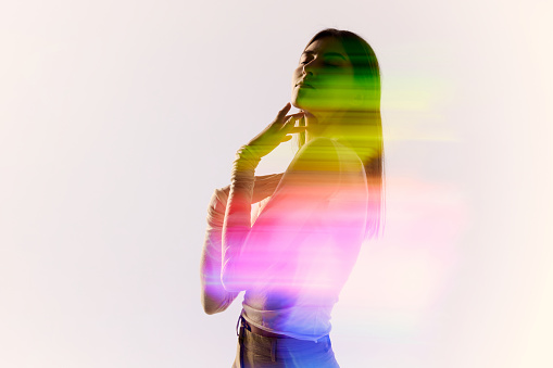 Tenderness. Silhouette portrait of young adorable woman posing over white background with mixed neon colored light on her body. Concept of contemporary art, fashion, futurism