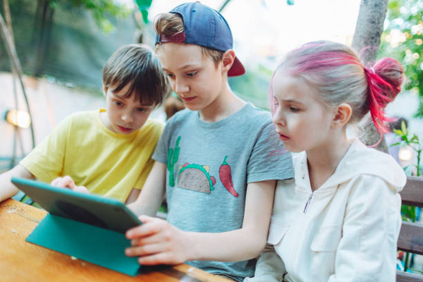 istock Three children playing games at digital tablet 1477523775