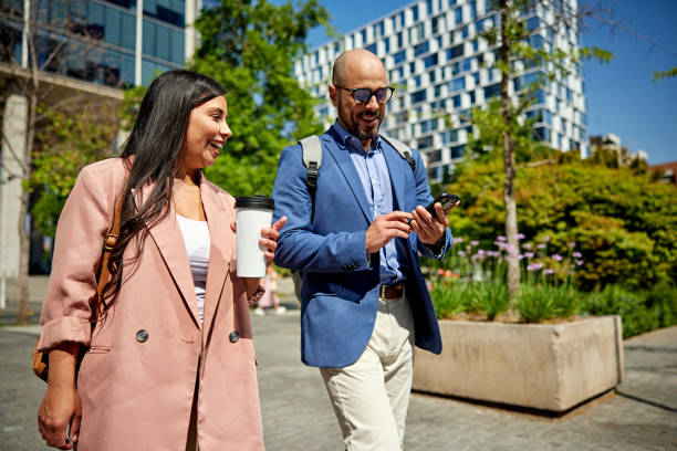 istock Smiling colleagues taking a break outdoors in office park 1477523919