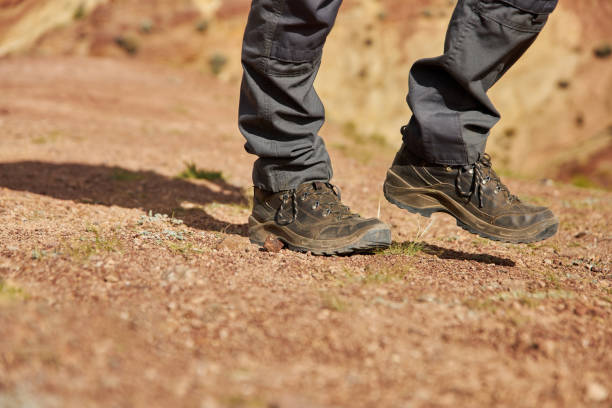 istock man legs in hiking boots climbs up the sandy hill 1477524224