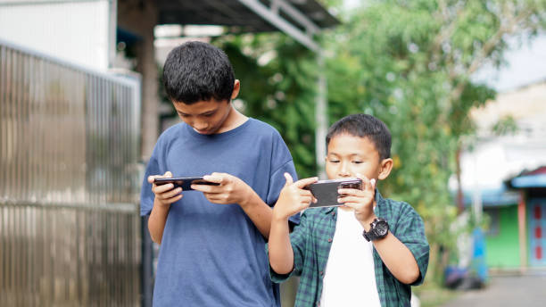 istock asian boys with brother using smartphone in outdoor 1477525871