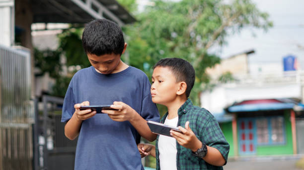 istock asian boys with brother using smartphone in outdoor 1477526516