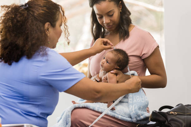 istock Trusting baby watches as nurse performs medical exam 1477528417
