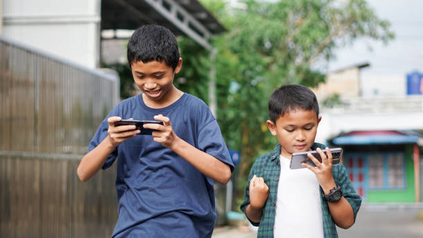 asian boys with brother using smartphone in outdoor