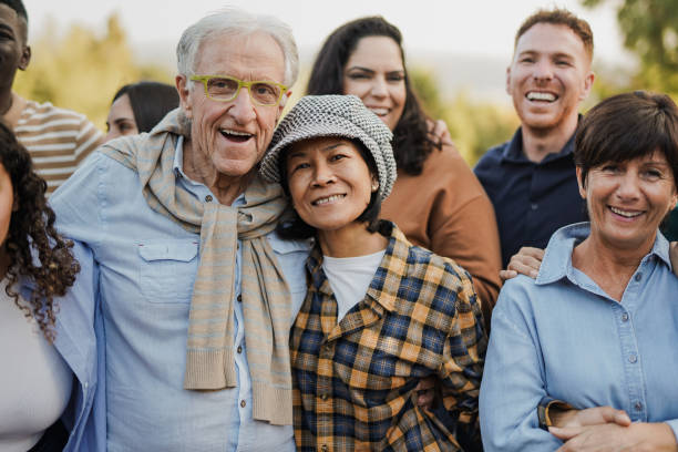 istock Group of multi generational people having fun together at city park while smiling on camera 1477530453