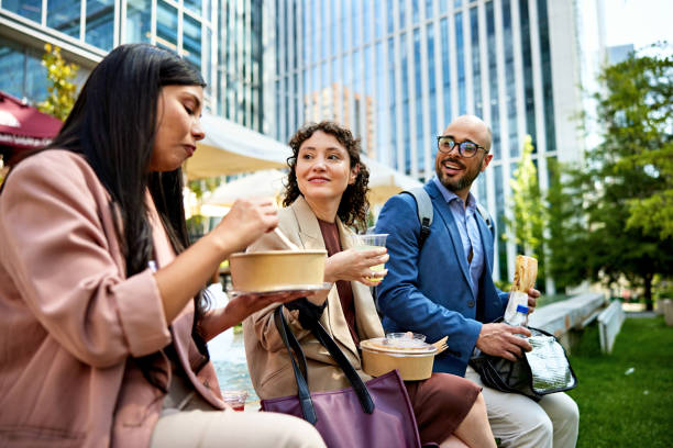 Office workers eating lunch together stock photo