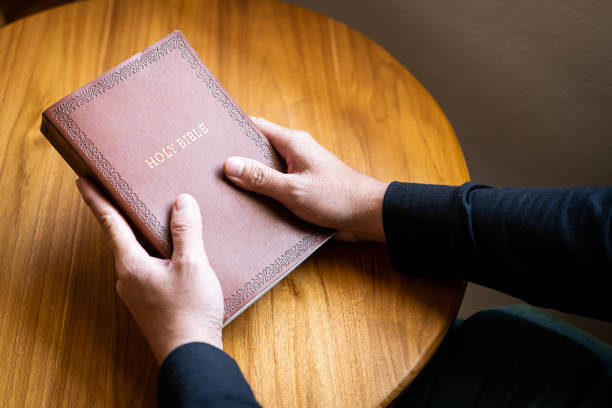 istock A man is holding and a Bible on the table with atmospheric lighting from the window symbolizing hope and God. Concepts of faith, spirituality and religion 1477537476