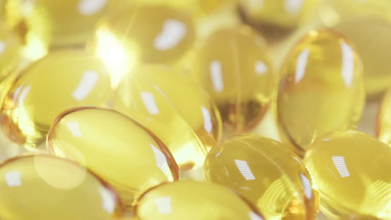 Yellow capsules of the Omega 3 vitamin pills in the healthy lifestyle concept