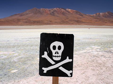 Sign with a skull and bones symbol warning of poisonous area in the Bolivian desert