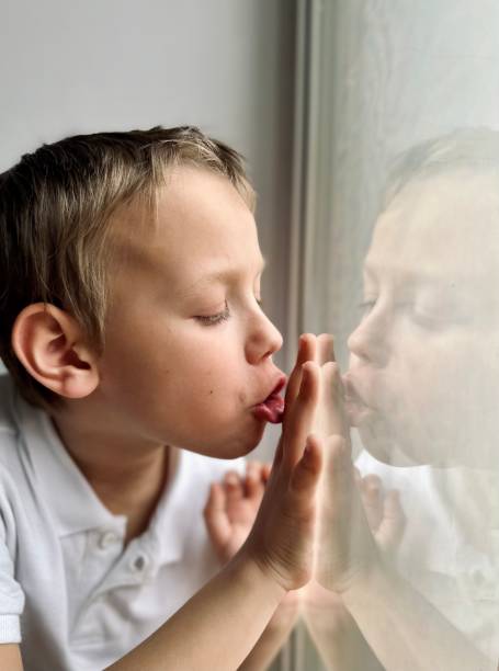 istock a boy in a white shirt looks out the window 1477540025