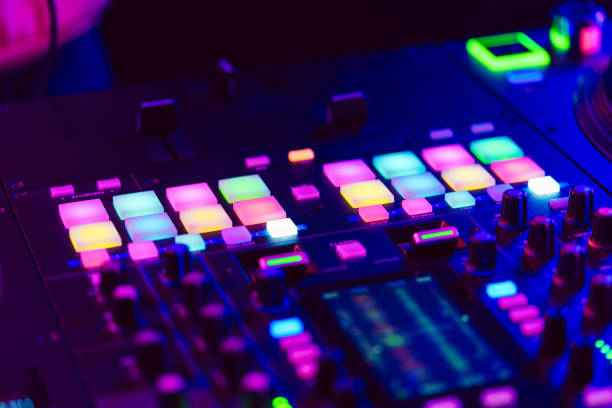 istock Close up of DJ mixing console in party light 1477542738