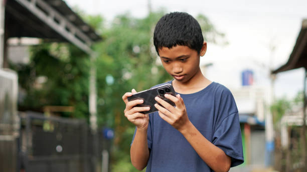 istock asian boy using smartphone in outdoor 1477542894