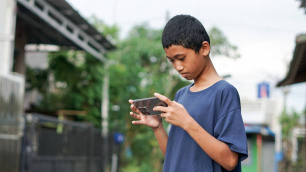 istock asian boy using smartphone in outdoor 1477543125