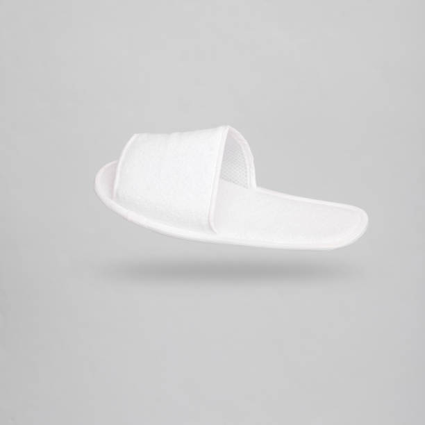 istock White hotel slippers levitating on a gray background with a shadow 1477543321