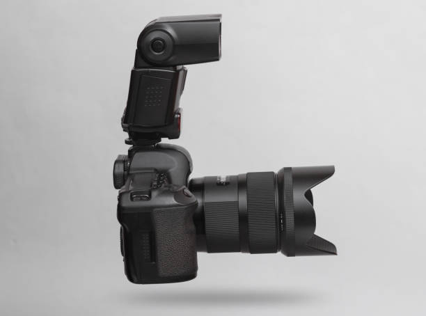 moderne digitale dslr-kamera mit objektiv und blitz, die auf grauem hintergrund mit schatten schwebt - lighting technique aperture lens color image stock-fotos und bilder