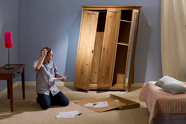 flatpack furniture man diy man checks the plans on his new self build wardrobe display cabinet photos stock pictures, royalty-free photos & images