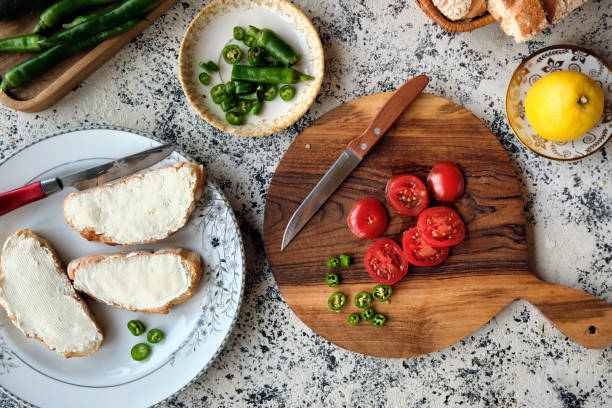 istock Top view chopped cherry tomatoes and green peppers for making bruschetta with cream cheese. 1477555100
