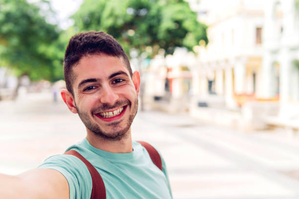 istock Cheerful ethnic man taking selfie on street 1477558427