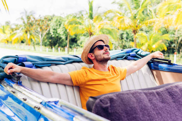 Satisfied man resting in car during trip