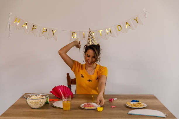istock Cheerful young woman having fun during a solo birthday celebration 1477558511