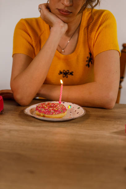 istock Young woman making a wish before blowing a birthday candle 1477558706